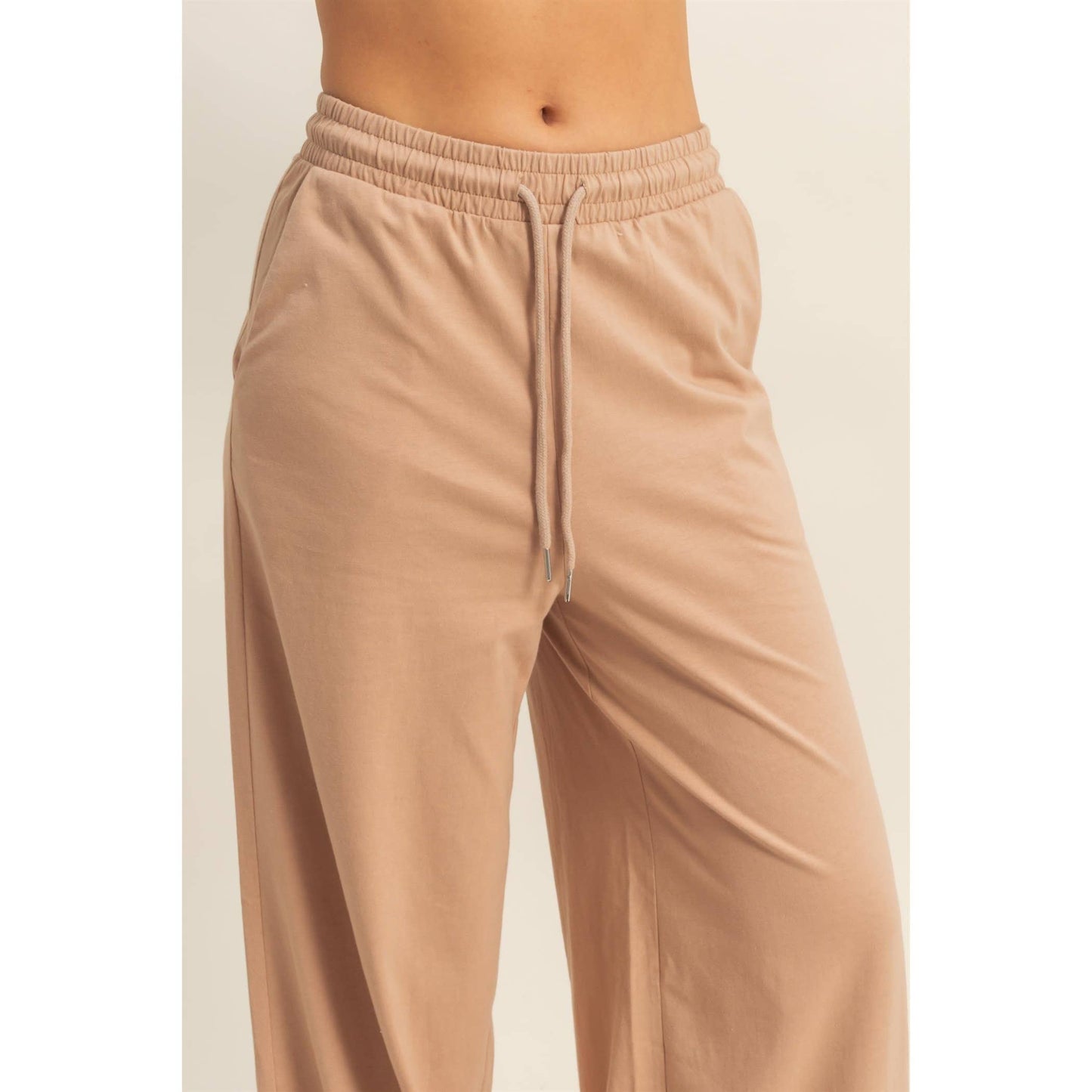 Beige lounge pants on a plain background
