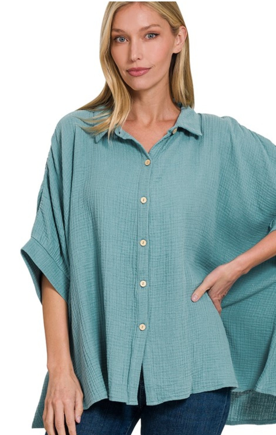 Woman wearing a teal button-up shirt with a white background
