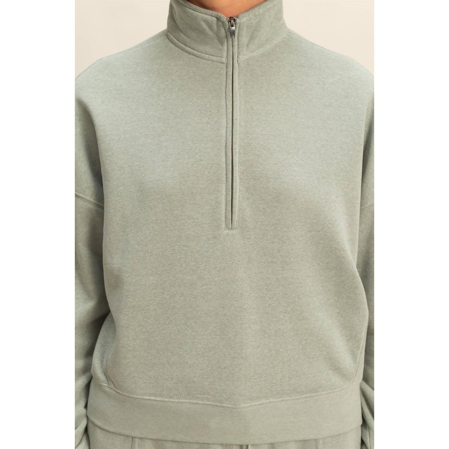 Light green half-zip sweatshirt on a white background
