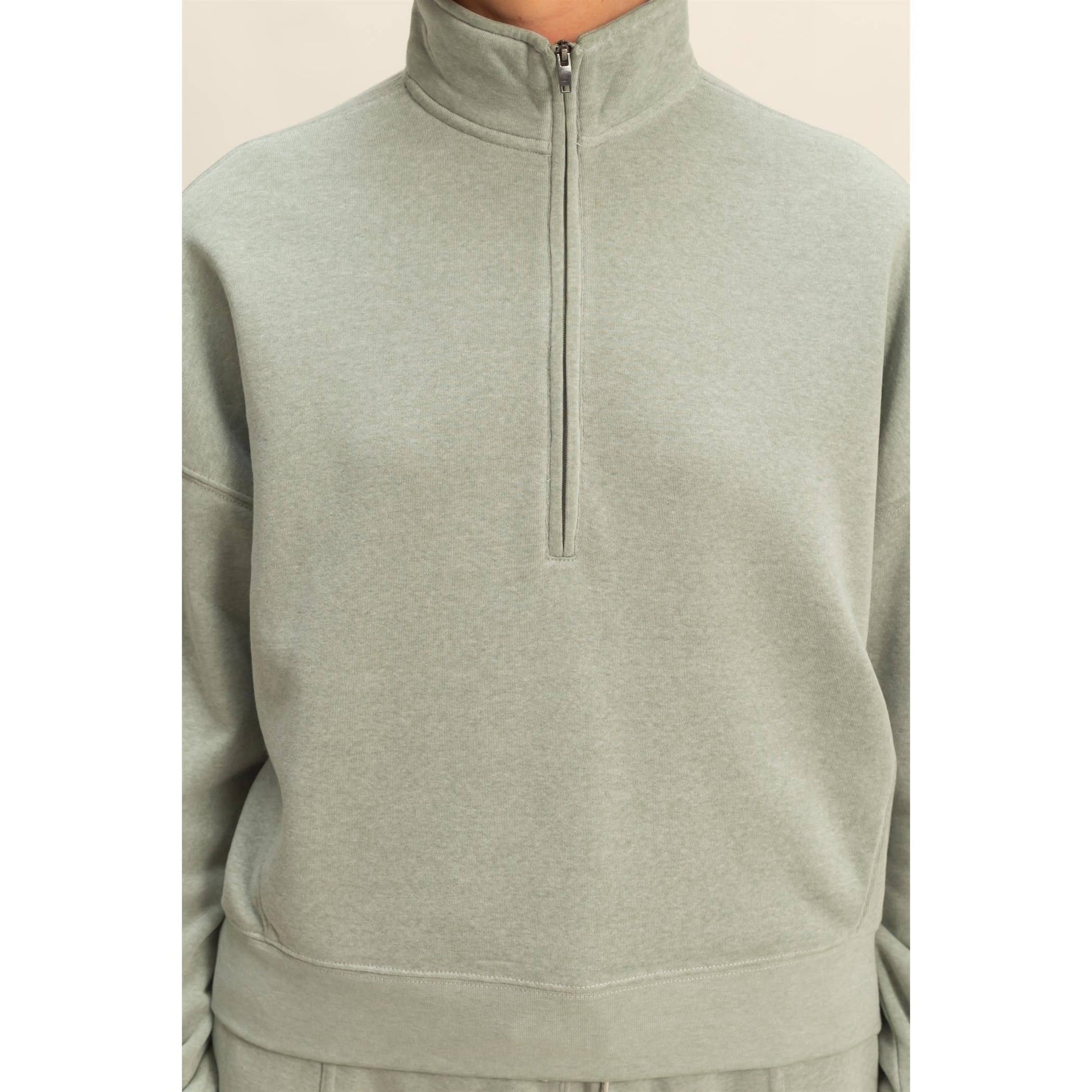 Light green half-zip sweatshirt on a white background