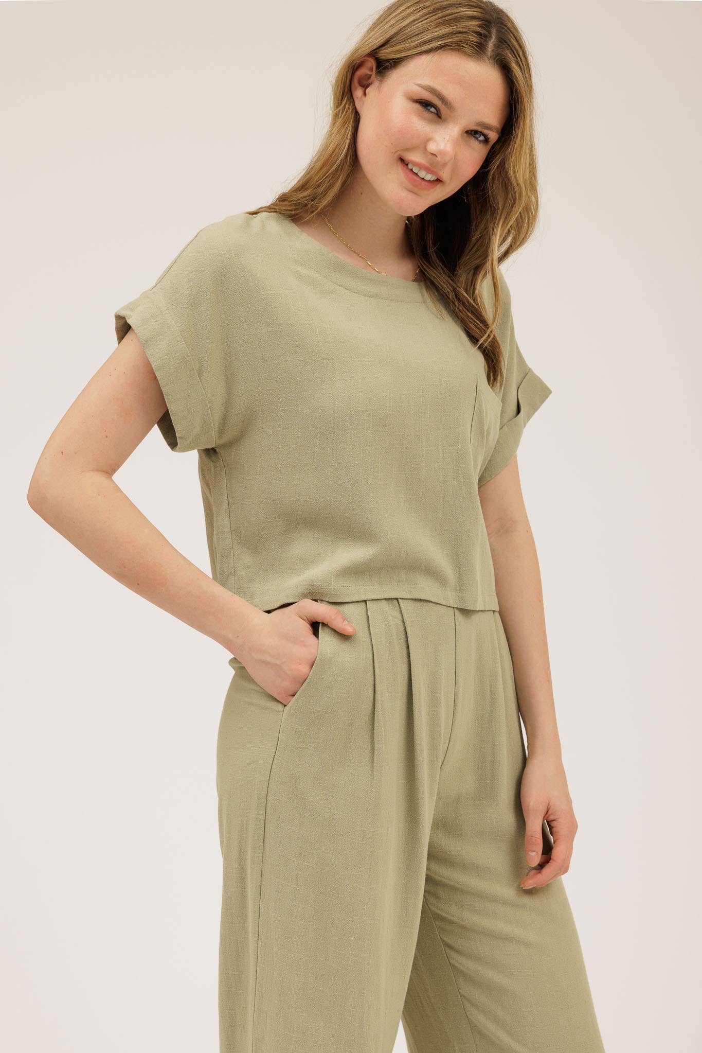 Woman wearing a green outfit with a plain background