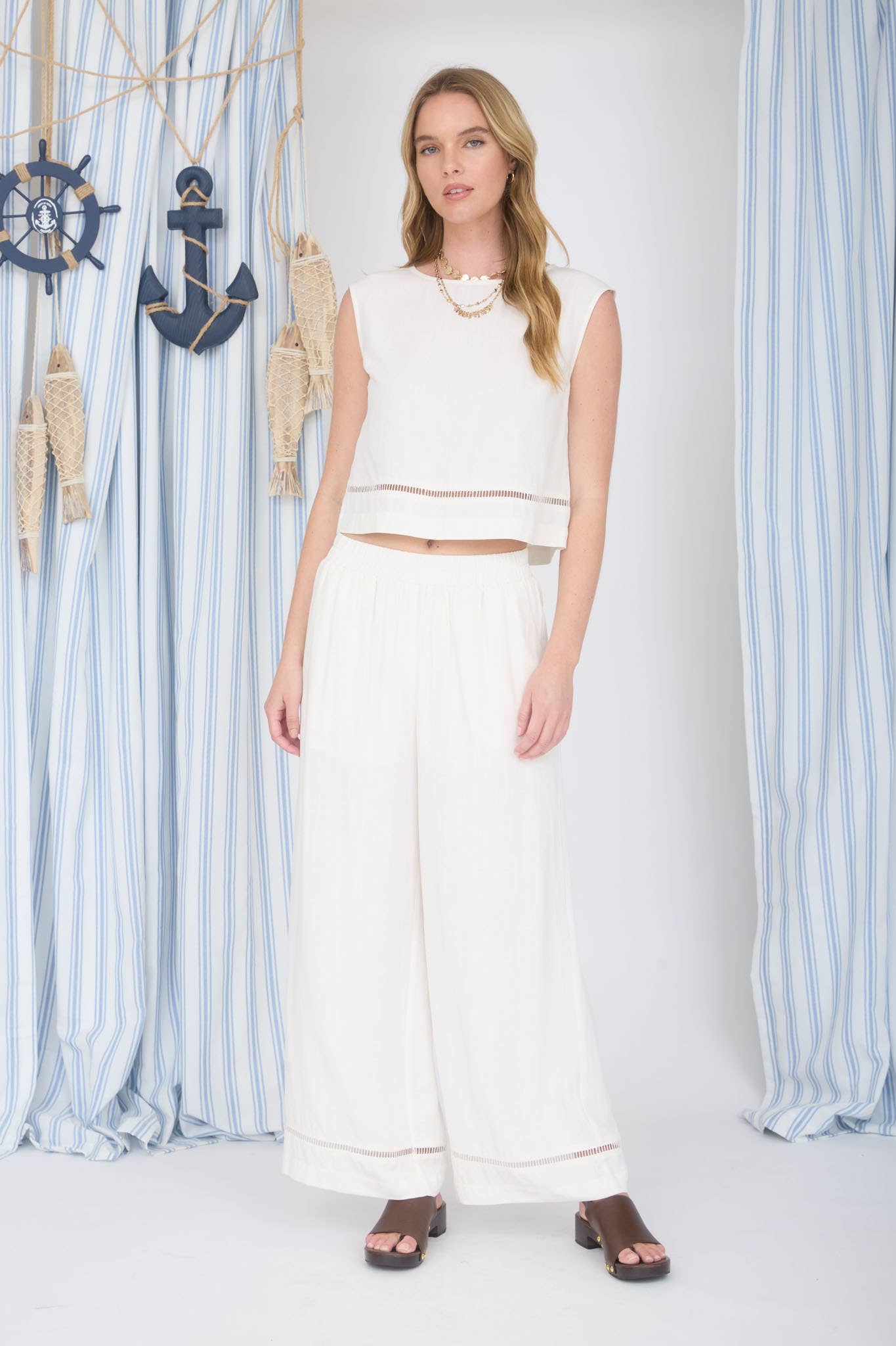 Woman wearing a white outfit with a nautical-themed background