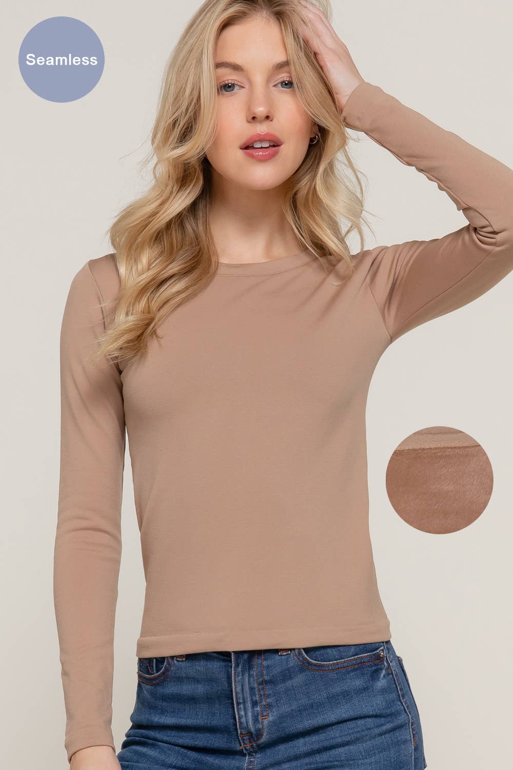 Woman wearing a beige long-sleeve top with a plain background
