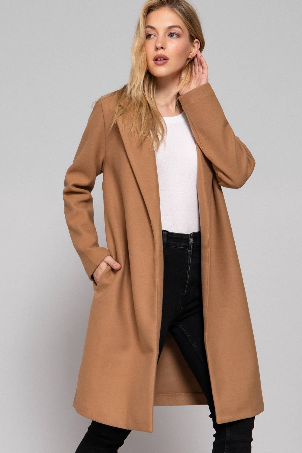 Woman wearing a brown coat on a plain background